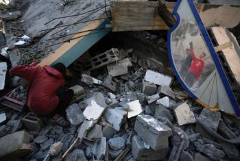 Varias personas buscan sus pertenencias entre los escombros del campo de refugiados de Nuseirat, en Gaza.