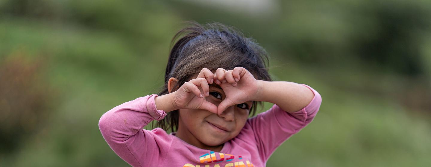 Una niña de cinco años hace un corazón con sus manos en la comunidad rural de Chajul, en Quiché Guatemala.