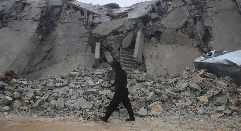 Un hombre pasa frente a un edificio dañado por un terremoto en Idlib, Siria.