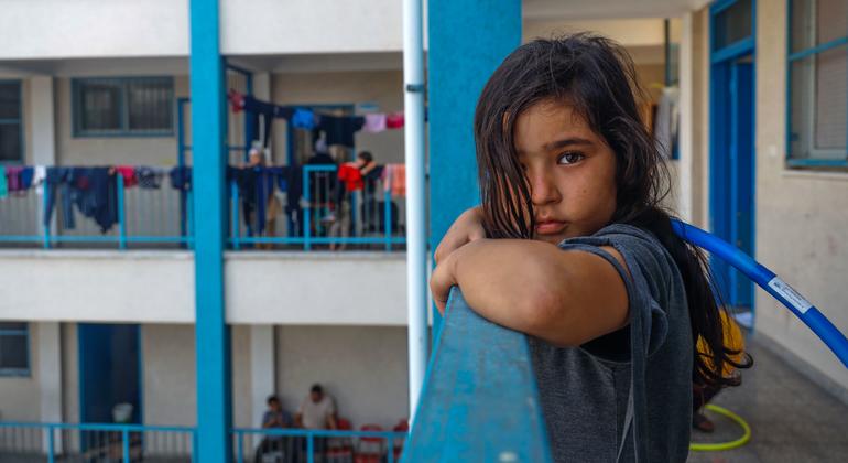 An eight-year-old girl, watches other children play in UNRWA school playground. "I want to play with them but I am afraid to leave the room. I don’t know how they can play without being scared, I just want to go back home", she said.