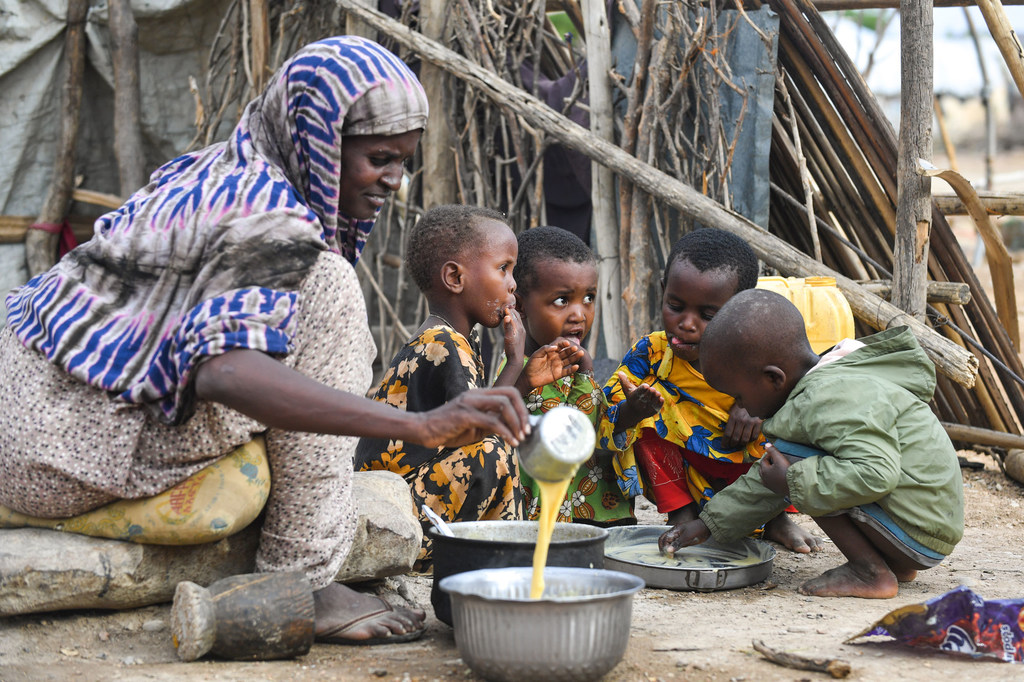 Des enfants mangent du gruau enrichi après la reprise de l'aide alimentaire aux réfugiés dans le camp de Bokolmayo, en Éthiopie.
