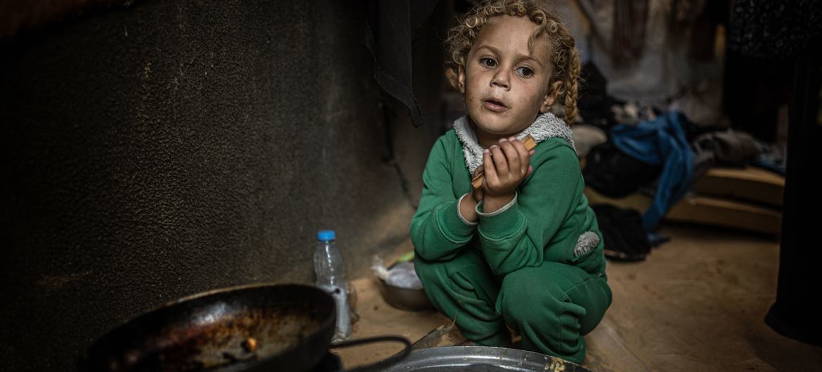 A young child in Gaza waits to be served food. A young child in Gaza waits to be served food.