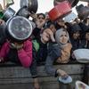 Des femmes attendent de recevoir de la nourriture, à un point de distribution dans la ville de Gaza.