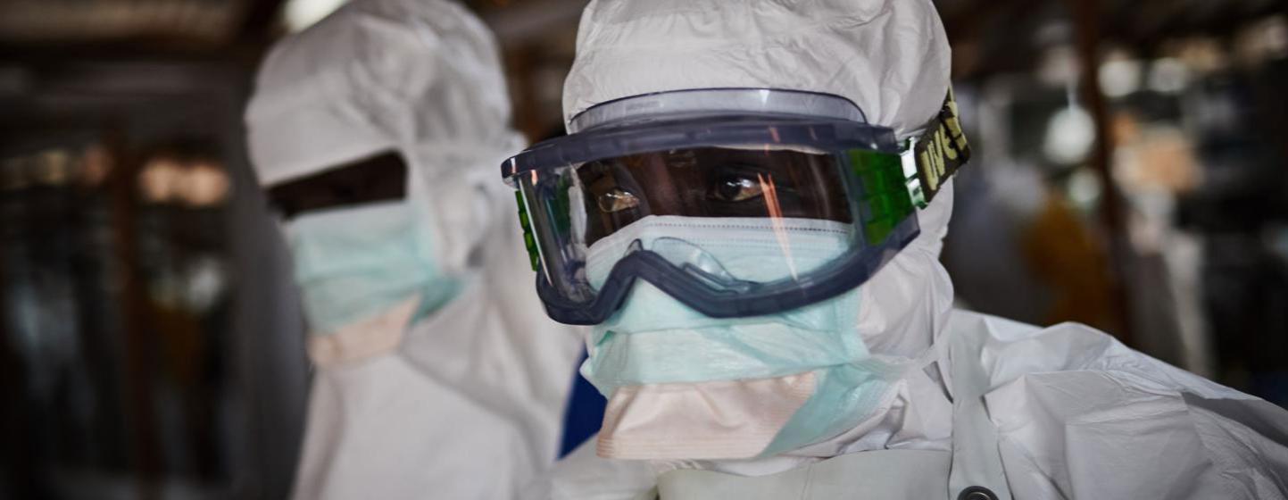 Des travailleurs de la santé en équipement de protection individuelle, notamment des boucliers faciaux et des masques, lors d'une épidémie en Ouganda.