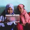 苏丹两名年轻女子在太阳能平板电脑上玩教育游戏。