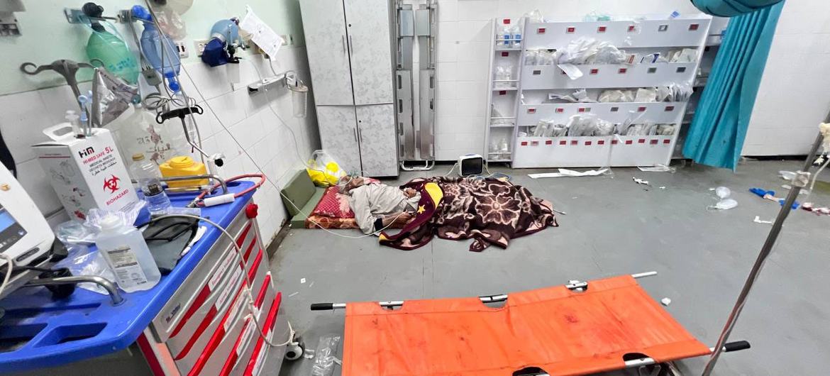 Le patient est allongé sur le sol d'une chambre d'hôpital, entouré d'équipements médicaux et de fournitures.