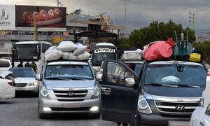 Cars loaded with luggage and belongings wait in a queue at the Masnaa border point in Lebanon, as people flee conflict and Israeli bombing to cross into Syria.