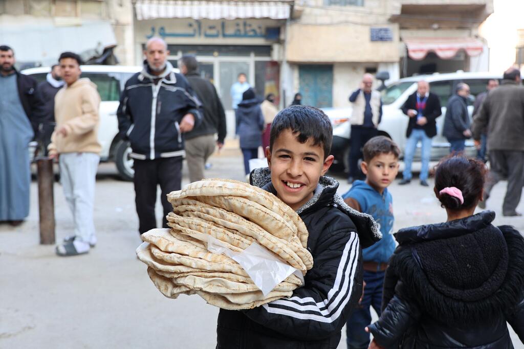 صبي يحمل خبزا في إحدى ضواحي دمشق، عاصمة سوريا.