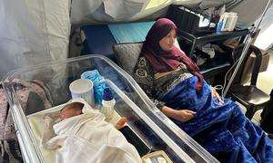 A woman who has recently given birth rests in a medical tent at Al Mawasi Field Hospital in Rafah in the Gaza Strip.