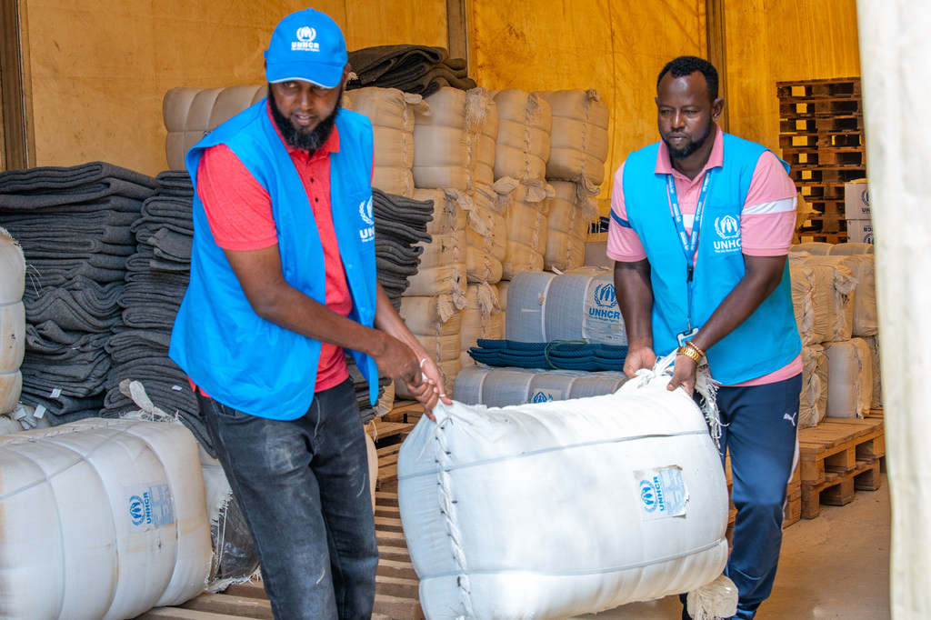 Wafanyikazi wa UNHCR wakihamisha vifaa muhimu vya msaada vitavyogawiwa kwa familia za wakimbizi waliokimbia makazi yao kutokana na mafuriko katika kambi za Dadaab.