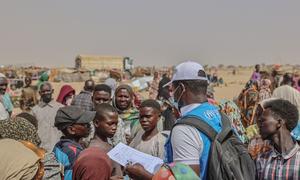 A UN worker in Chad talks to newly arrived refugees from Sudan.thousands in desperate need