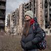 A 13-year-old girl walks past buildings damaged by the shelling in Irpin, Ukraine. 