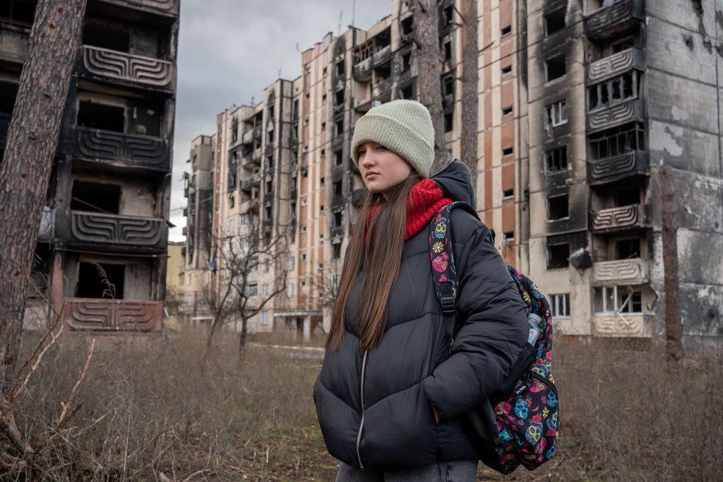 Una niña de 13 años pasa junto a edificios dañados por los bombardeos en Irpin, Ucrania. 