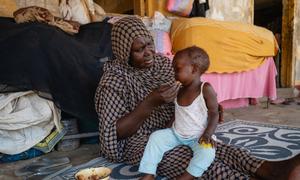 A woman feeds a child at a school used as a gathering point for displaced people in Port Sudan. (file)