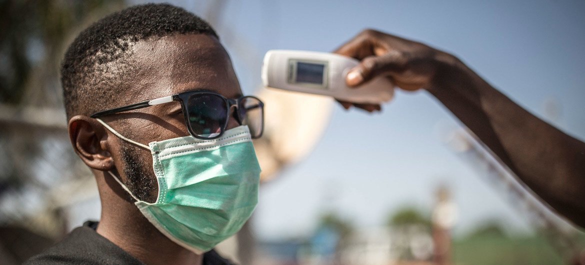 A man's temperature is taken in Mali to check against a possible COVID-19 infection. 