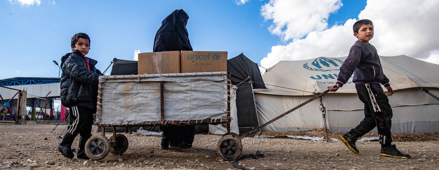 A family receives clothes for the winter from UNICEF in Al-Hol camp in northeastern Syria.