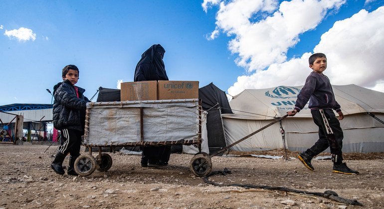 أسرة تحصل على الملابس استعدادا لفصل الشتاء من اليونيسف في مخيم الهول شمال شرق سوريا.