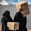 Displaced people living in Al-Hol camp in northeastern Syria carry newly received winter clothing kits, distributed by UNICEF. 