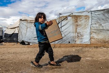 在叙利亚东北部的霍尔难民营，一名儿童拿着儿童基金会分发的冬装包。
