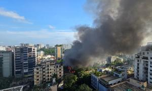 Smoke rises from a store set on fire by protestors in Dhaka, Bangladesh.