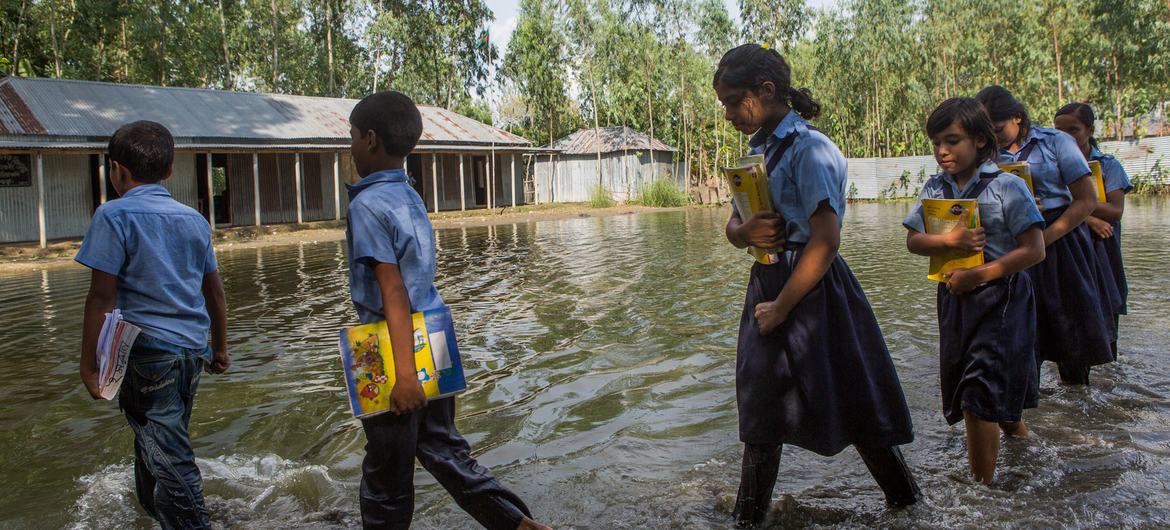 Estudiantes se dirigen al colegio tras las fuertes inundaciones en Sariakandi Upazila, en Bangladesh, en septiembre de 2024.