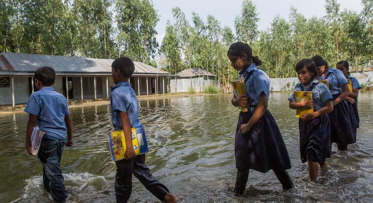 Estudiantes se dirigen al colegio tras las fuertes inundaciones en Sariakandi Upazila, en Bangladesh, en septiembre de 2024.