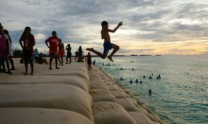 Children in the Pacific Ocean island of Tuvalu play at a coastal area protected by sandbags.