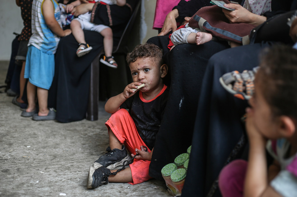 Des enfants mangent des biscuits à haute teneur énergétique dans une clinique à Gaza.