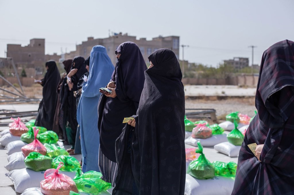 Des femmes reçoivent des rations alimentaires dans un centre de distribution à Herat, en Afghanistan.