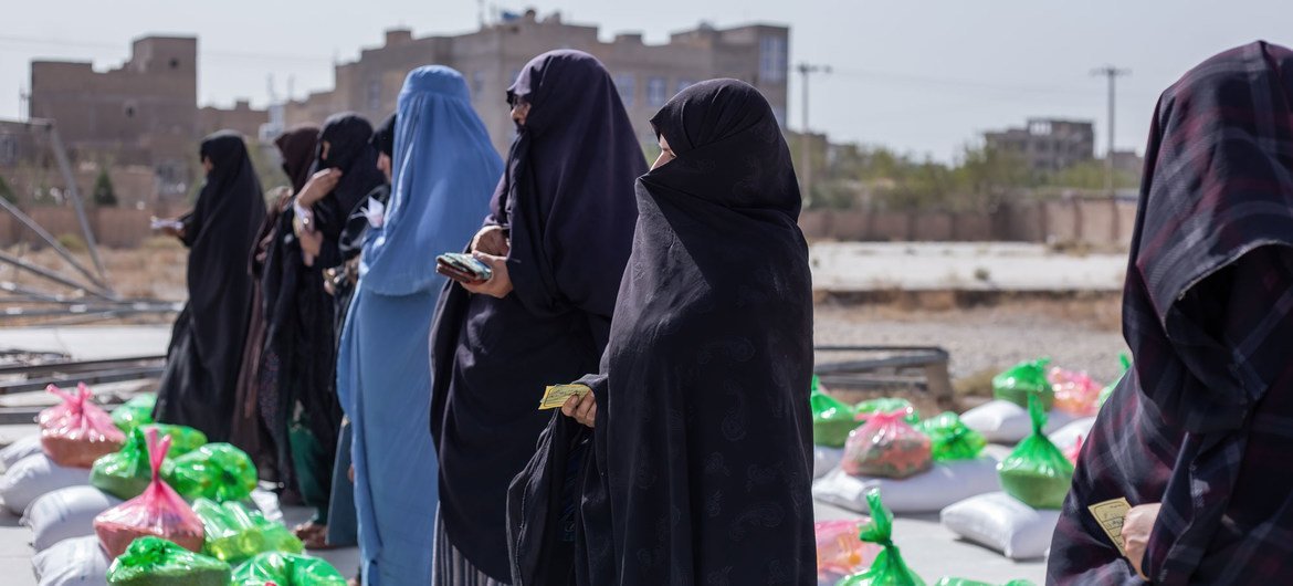 Des femmes reçoivent des rations alimentaires dans un centre de distribution à Herat, en Afghanistan.