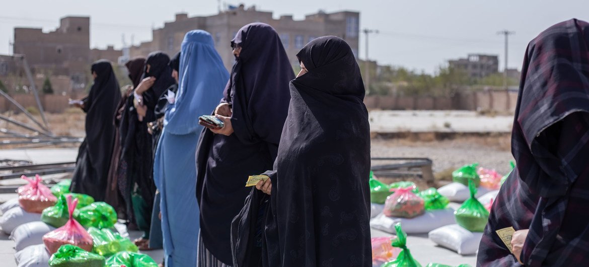 نساء يتلقين حصصاً غذائية في أحد مواقع توزيع المواد الغذائية في هيرات، أفغانستان.