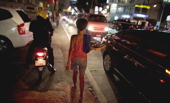 فلپائن کے دارالحکومت منیلا کے ’ریڈ لائٹ‘ ایریا میں رات کے وقت ایک چھابڑی فروش بچہ سڑک کنارے گزر رہا ہے۔