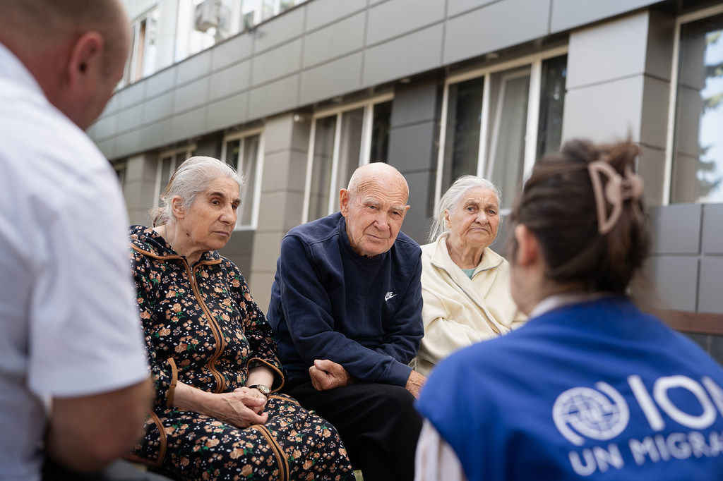 Yuri (centre) and two women are counselled by an IOM staff member.