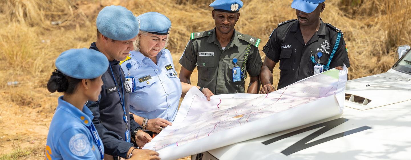 La commissaire de police Christine Fossen, de l'UNMISS, dirige une équipe de femmes uniformées de la force de maintien de la paix au Soudan du Sud, en train d'examiner une carte sur le capot d'un véhicule.