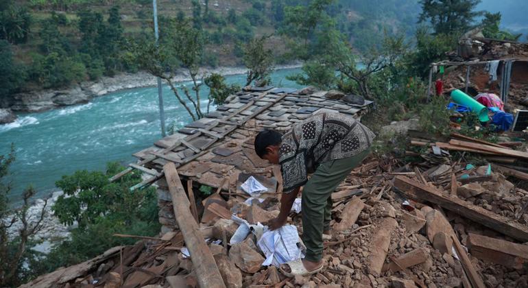 Un niño busca entre los escombros de su casa afectada por el terremoto en Rukum Occidental, Nepal.