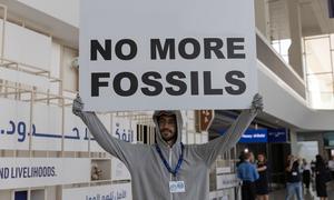 Un hombre protesta contra los combustibles fósiles en una reunión internacional sobre el clima en Dubái en 2023.