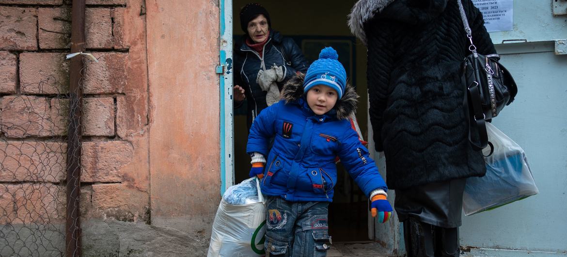 Uma família recebe roupas de inverno para crianças e outros suprimentos da UNICEF na comunidade da linha de frente de Marhanets, na Ucrânia.  (arquivo).