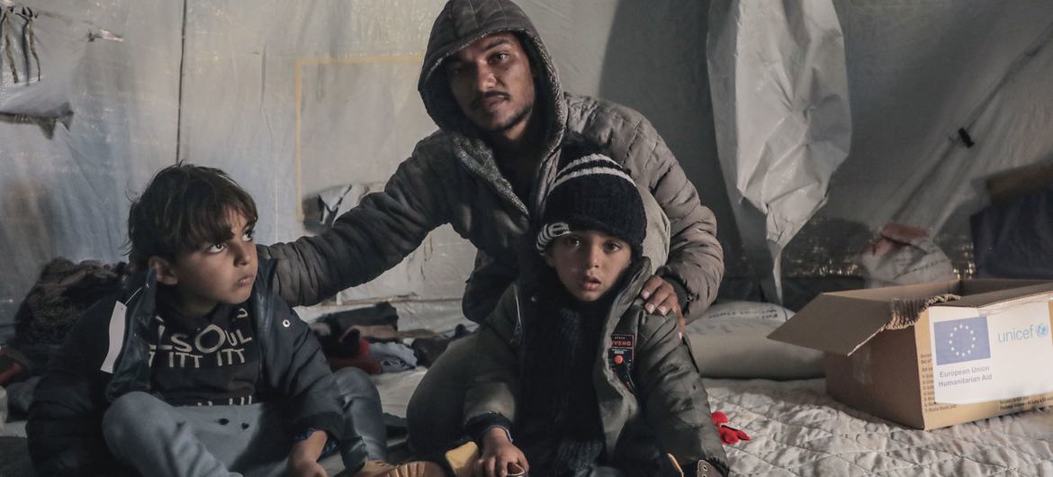 A displaced family receive winter clothes in Der Al Balah, central Gaza.