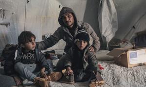 A displaced family receive winter clothes in Der Al Balah, central Gaza.