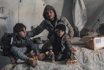 A displaced family receive winter clothes in Der Al Balah, central Gaza.