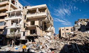 People search through the rubble of a bombed building in Tyre in southern Lebanon. 