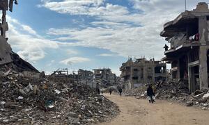 La destrucción en Jabalya, en el norte de Gaza, con personas caminando por calles llenas de escombros y edificios dañados bajo un cielo parcialmente nublado.