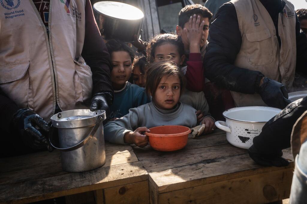 孩子们在加沙的汗云斯的厨房里等待热餐,