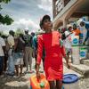 Uma mulher recolhe itens de socorro distribuídos pelo Unicef