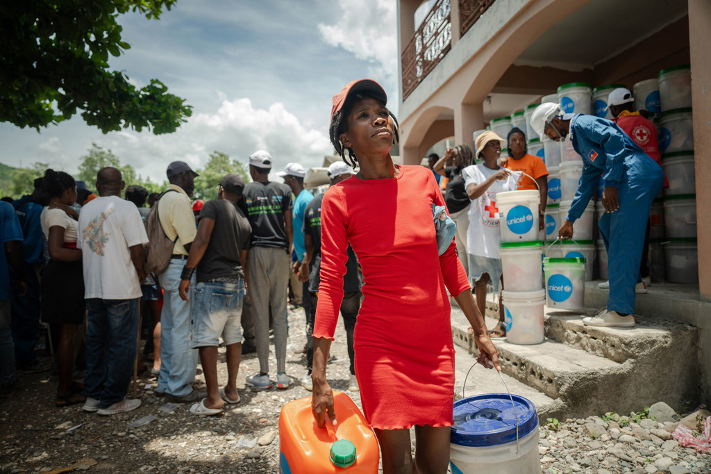 A woman collects relief items distributed by UNICEF.