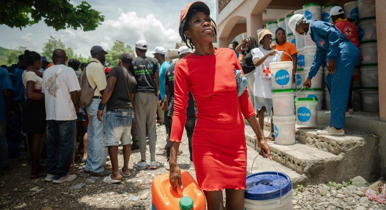 Una mujer recoge artículos de socorro distribuidos por UNICEF.