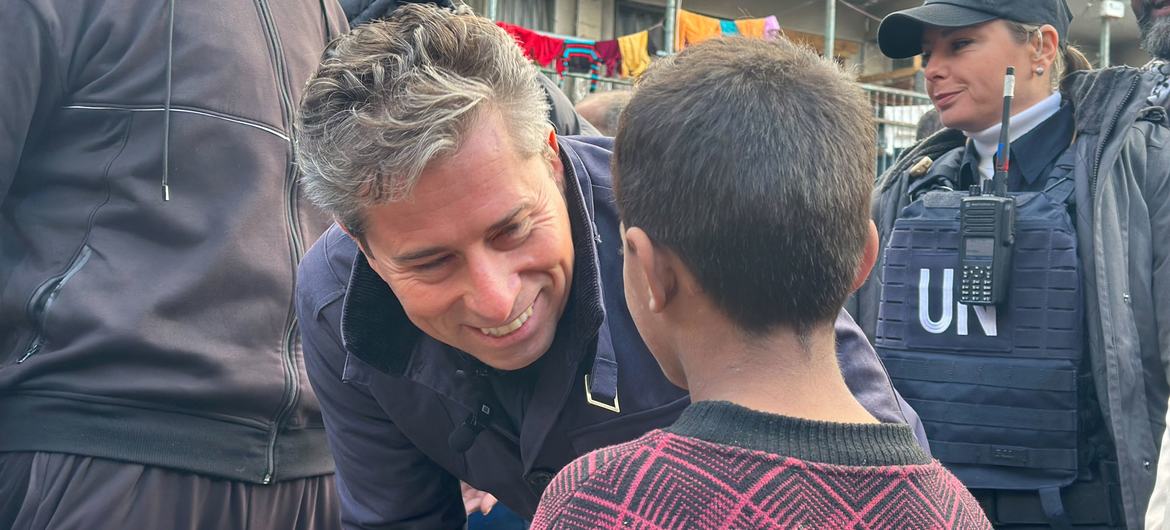 UN Relief Chief Tom Fletcher talks to a child at an UNRWA shelter in Gaza.