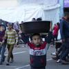 在加沙地带卡斯塔的一所学校，一个男孩头上顶着大盆。 
