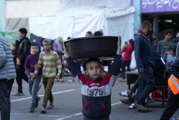 A boy carries a large bowl on his head at the Al-Qastal School in the Gaza Strip.