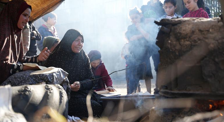 Gaza Strip.  A woman cooks flat bread in a clay built oven the Al-Qastal School.